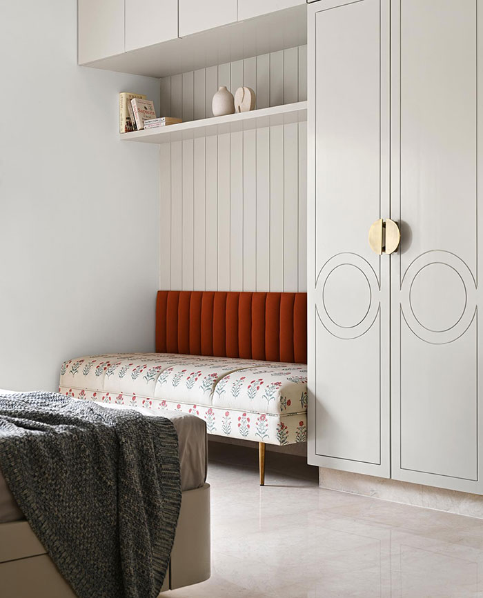 Different zones in a bright bedroom with red accents 