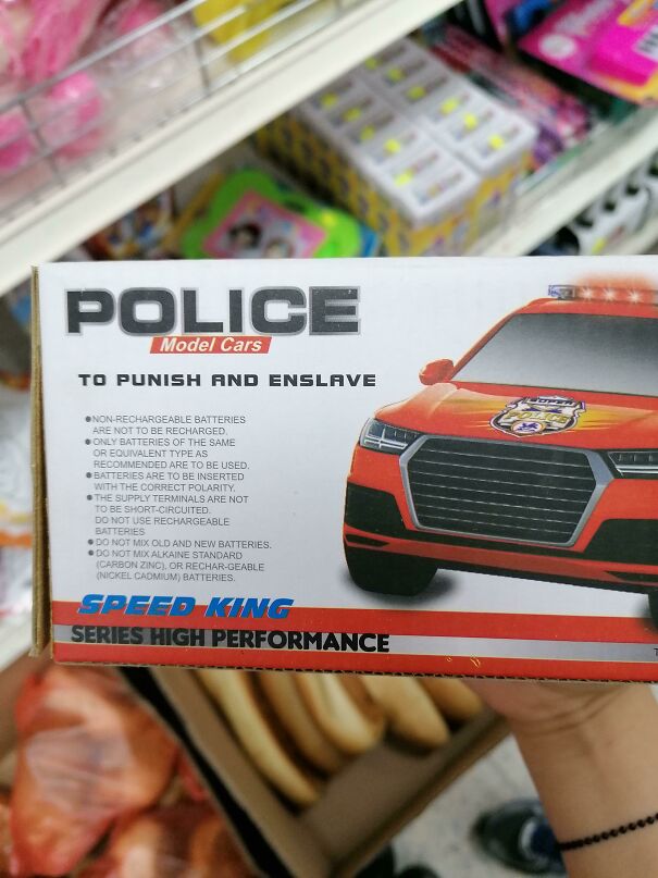 Toy police car box with funny English translation warning about batteries to punish and enslave.